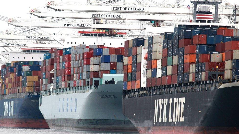 Container ships are positioned under cranes at the Port of Oakland