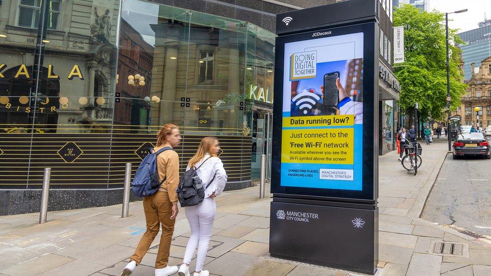 People alongside and information screen