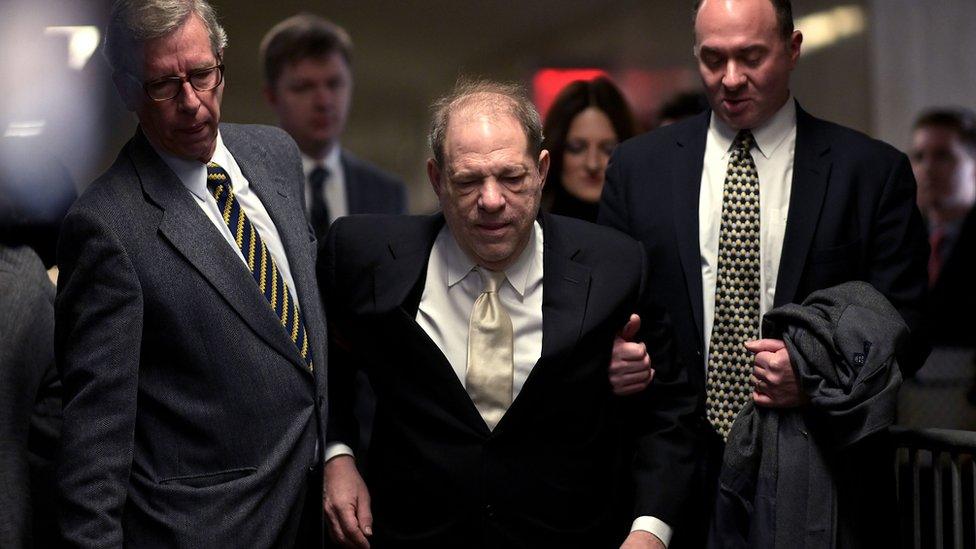 Weinstein is supported by two men, walking without a walker, on January 23