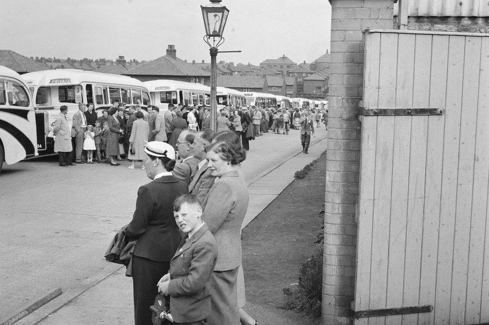 Workers outside a queue of buses