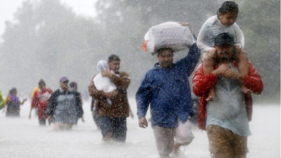 Residents wade through flood waters from Tropical Storm Harvey in Beaumont Place, Texas, 28 August 2017