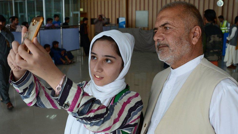 Afghan teenager Fatemah Qaderyan takes a photograph with her father at Herat airport on on July 13, 2017