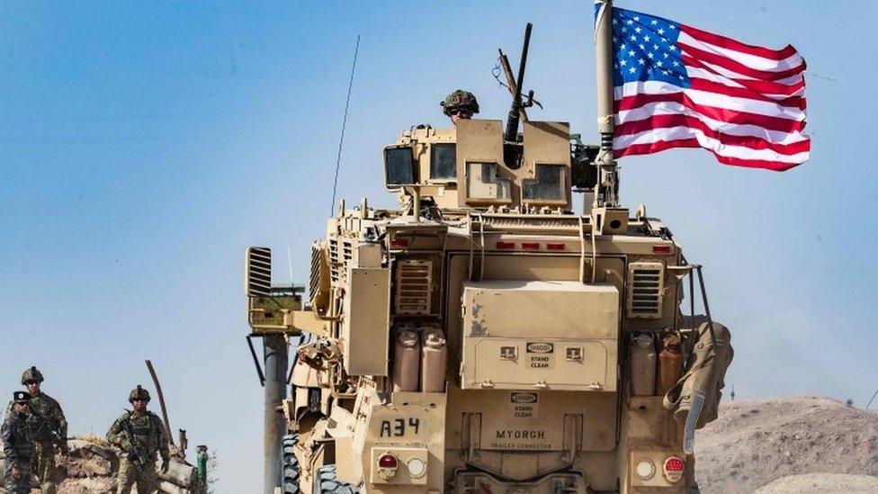 A US soldier on an armoured vehicle during a demonstration by Syrian Kurds at a US-led international coalition base on the outskirts of Ras al-Ain town