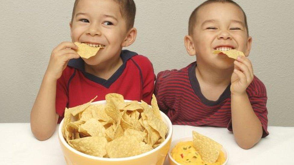 Two children eating junk food