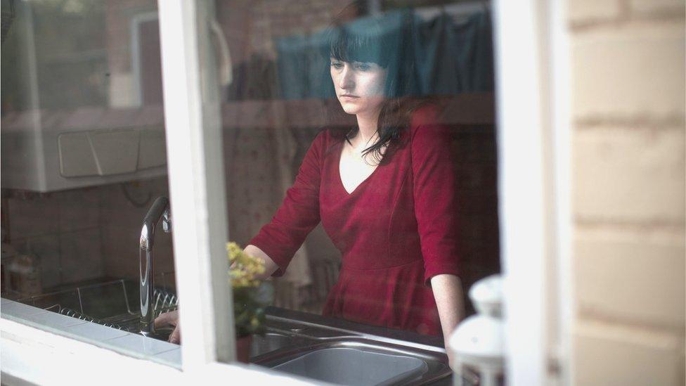 Worried woman looking out the window