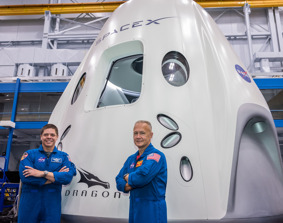 Behnken (L) and Hurley pose for pictures in front of the Crew Dragon