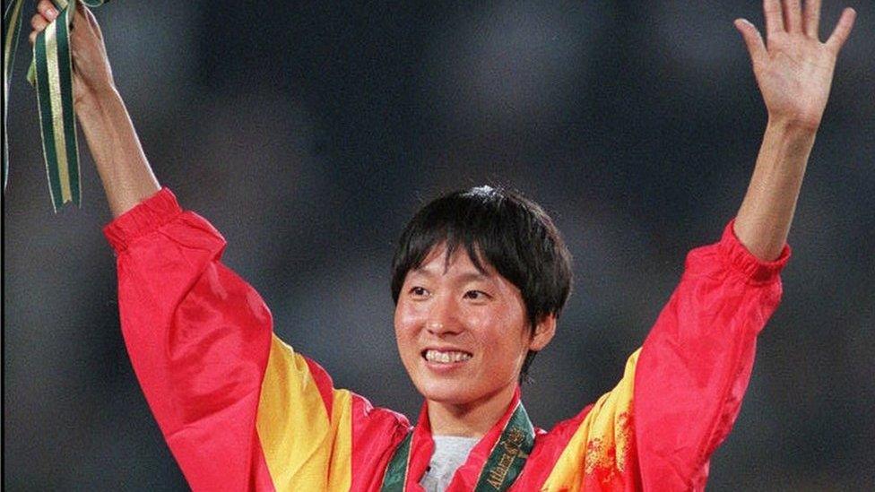 Wang Junxia from China celebrates on the podium during the medal ceremony after winning the gold medal in the women's Olympic 5,000m event at the Olympic Stadium in Atlanta, Georgia, 28 July 1996