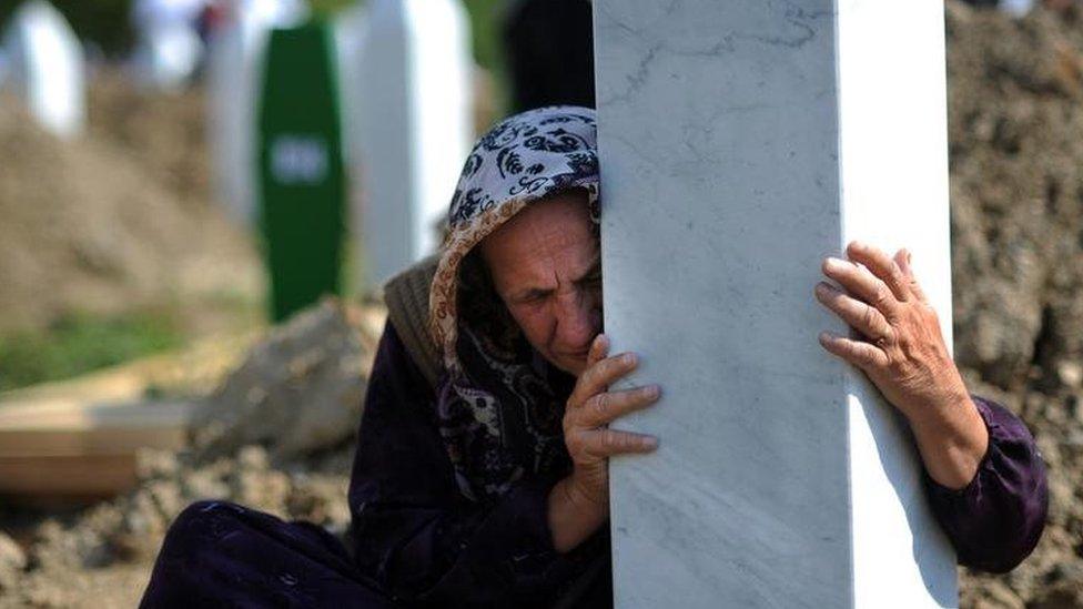 A Bosnian woman embraces a grave stone during a mass burial of newly identified victims of the 1995 Srebrenica massacre at the Potocari memorial cemetery. Photo: July 2010