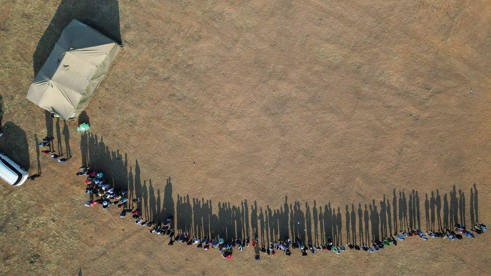 Zimbabwean citizens wait in a queue at a polling station before voting commences in Mabvuku suburb on August 23, 2023 in Harare, Zimbabwe