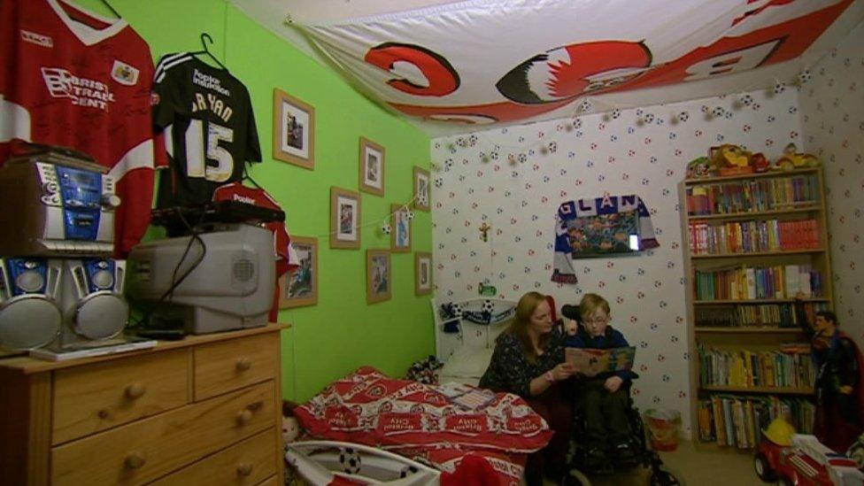 Oskar with his mum Lizzie in his bedroom which is covered with Bristol City merchandise and memorabilia