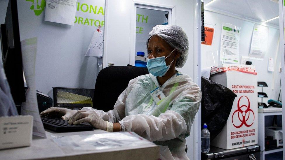 A medical staff member of the South Africa Health Department works at a computer in a mobile testing unit at O.R Tambo International Airport in Ekurhuleni on December 30, 3030, where passengers that have COVID-19 symptoms upon arrival are tested. (Photo by Luca Sola / AFP) (Photo by LUCA SOLA/AFP via Getty Images)