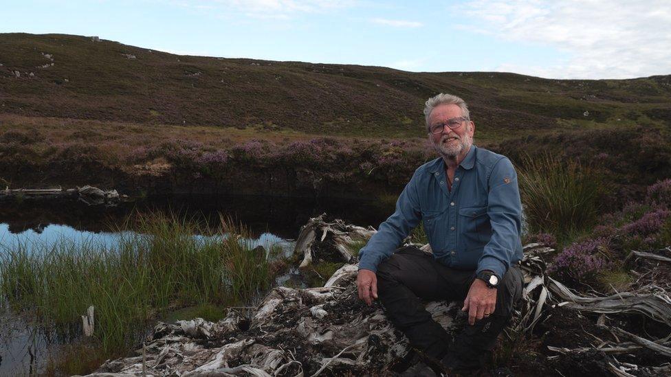 Cormac Ó hÁdhmaill sitting in a peatland