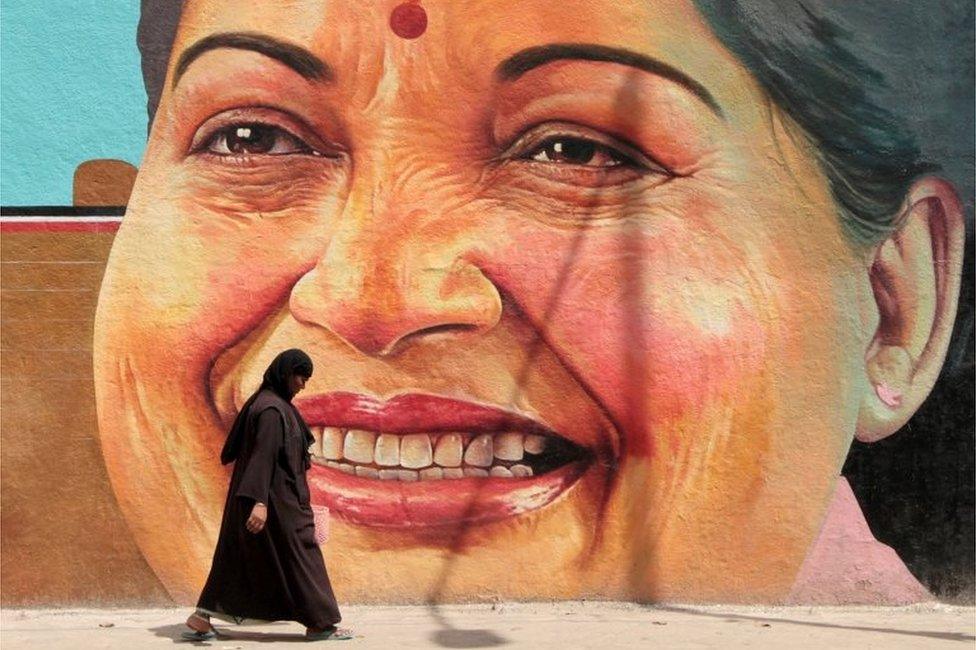 A woman walks past a portrait of J. Jayalalithaa, Chief Minister of the southern state of Tamil Nadu, in Chennai, India, March 13, 2012.