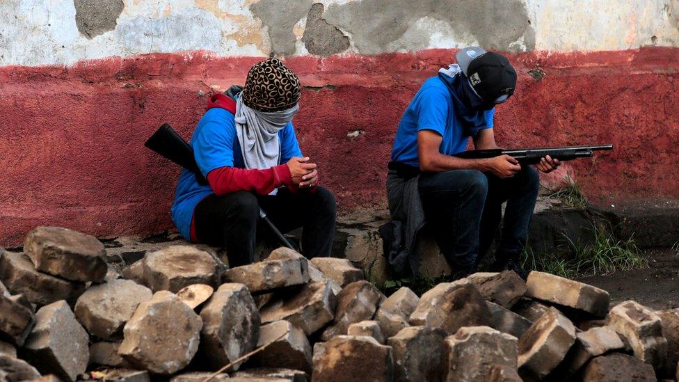 Pro-government supporters sit in a barricade after clashes with demonstrators in the indigenous community of Monimbó, 17 July 2018