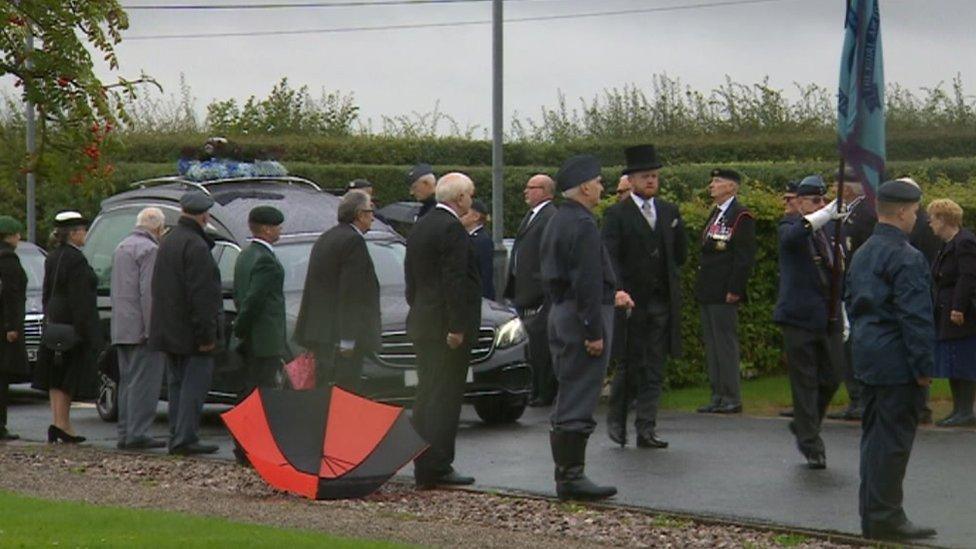 Military personnel line the route of the cortege