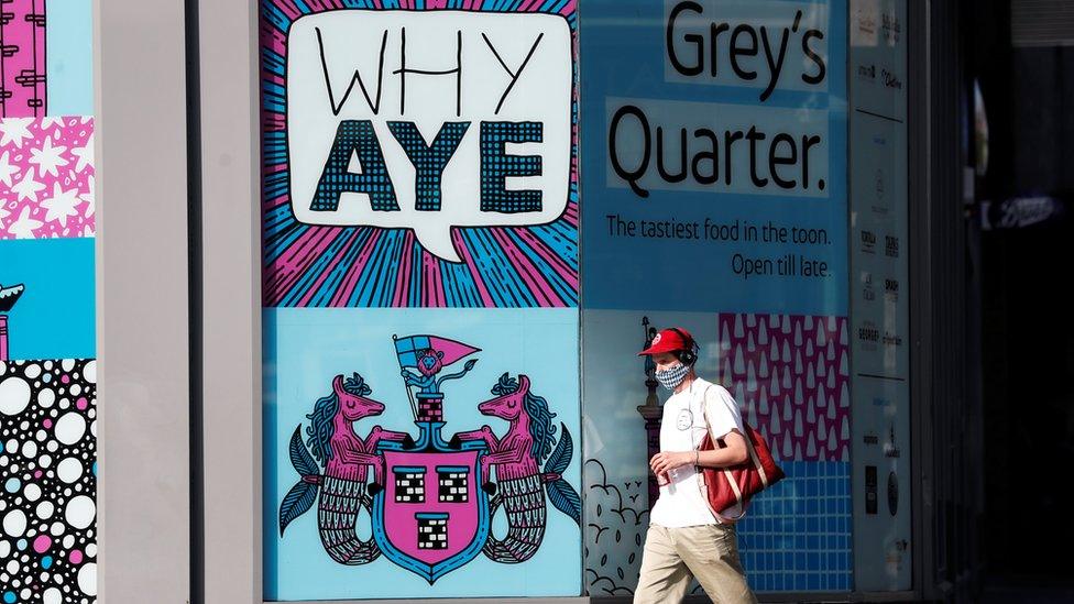 Man wearing a mask walking through the centre of Newcastle