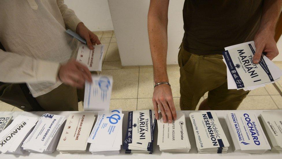 French residents pick up their ballots before casting their vote in the French legislative elections at the French embassy in New Delhi on 4 June 2017