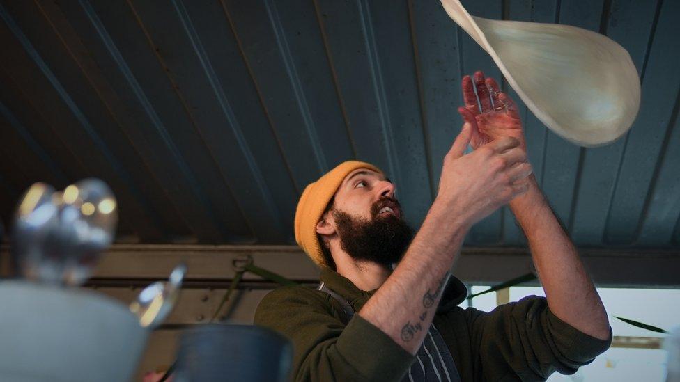 Man throwing a pizza