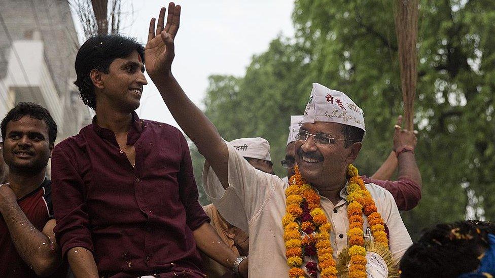 AAP leader Arvind Kejriwal waves as he rides on an open jeep during a rally 9 May 2014 in Varanasi