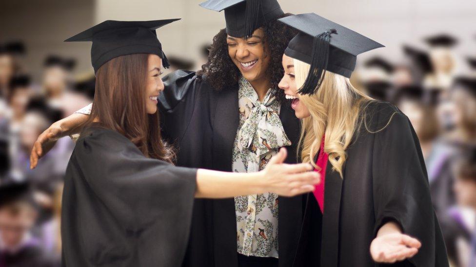 three friends hug at their graduation