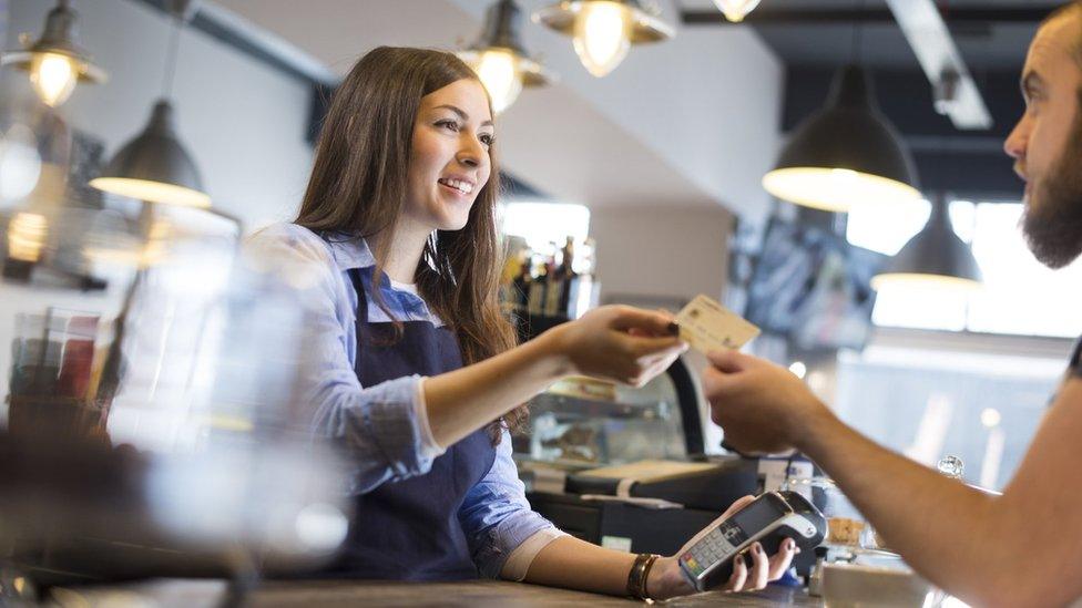 Waitress accepting a customers' payment.