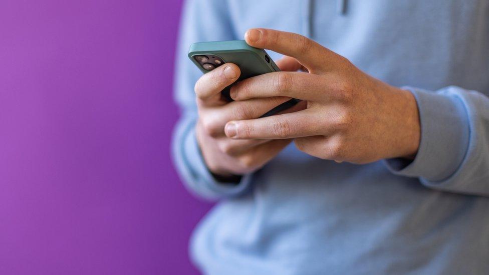 Young person holding a mobile phone