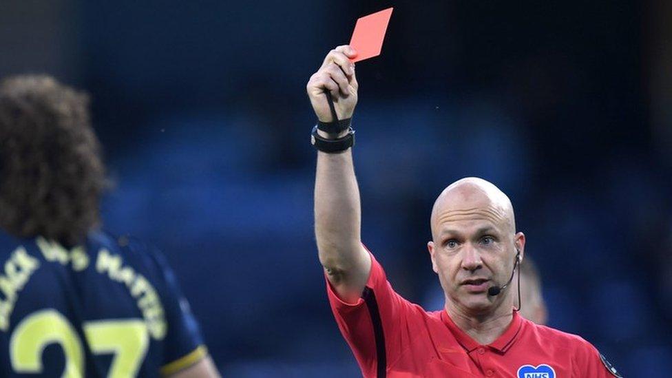 Referee Anthony Taylor showing Arsenal"s David Luiz a red card during a Premier League match