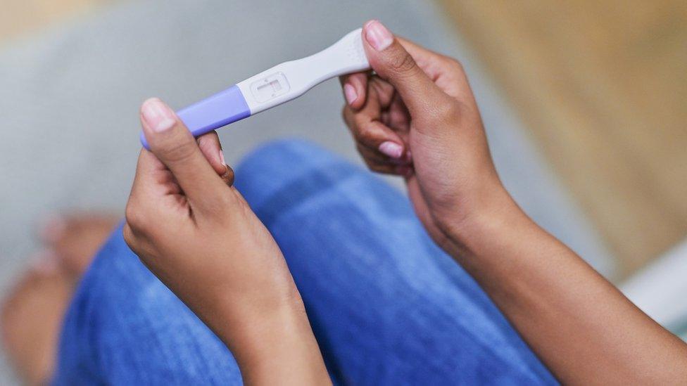 Woman holding a pregnancy test