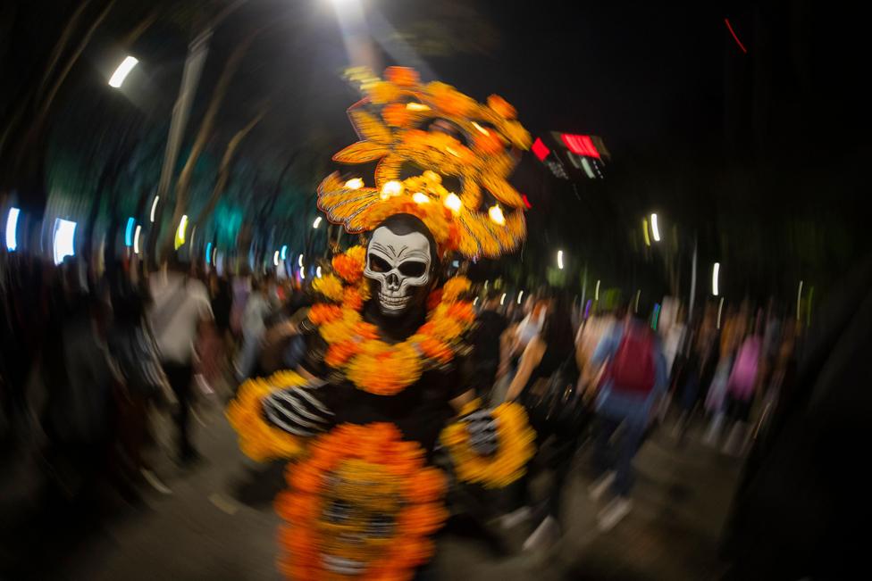 People dressed in costumes participate in the Catrinas procession as part of the celebrations for the Day of the Dead, in Mexico City, Mexico, 22 October 2023.