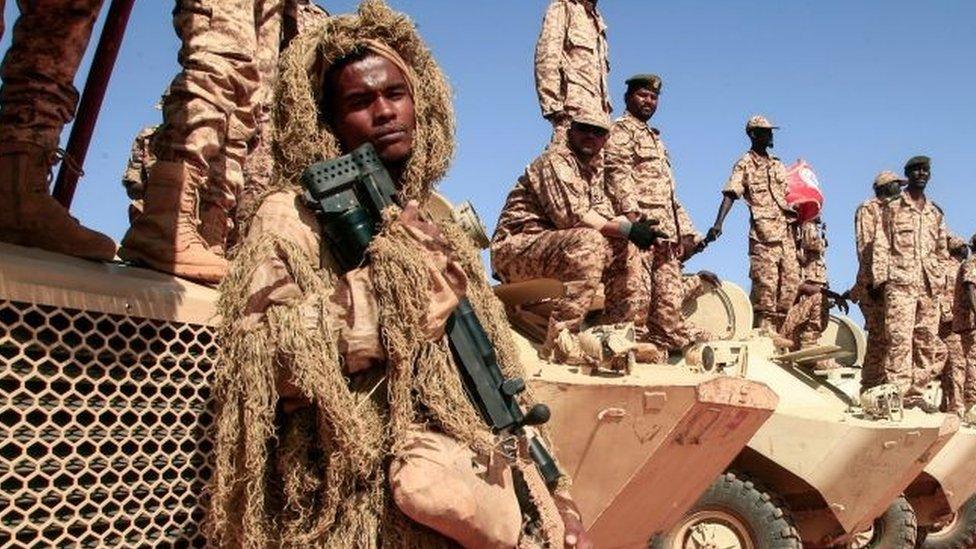 Sudanese soldiers stand next to their vehicles during a military exercise in the Maaqil area in the northern Nile River State, on December 8, 2021