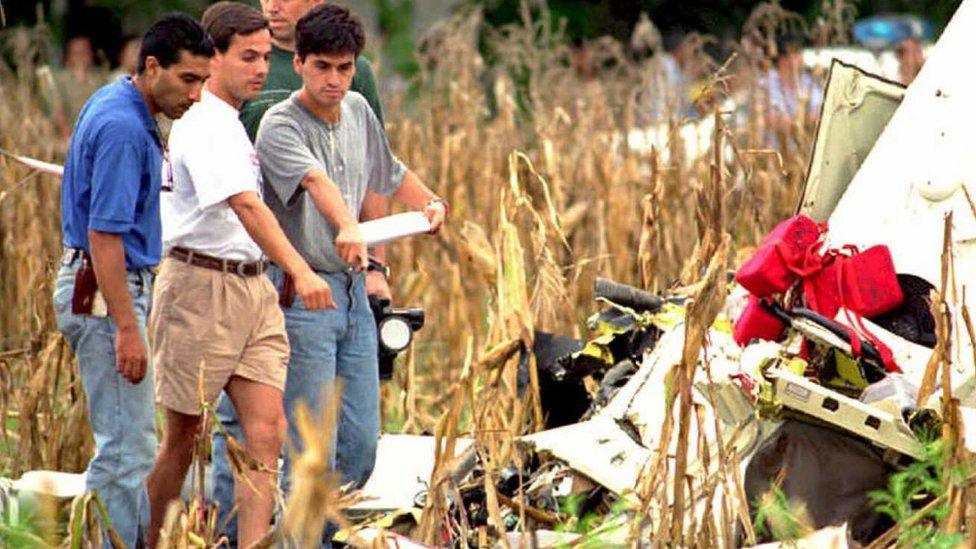 Journalists and curiousity seekers look at the wreck of the helicopter that carried Carlos Facundo Menem