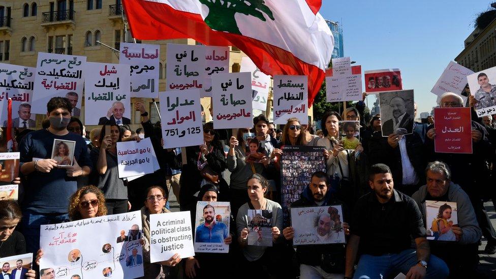 Families of victims of the 4 August 2020 Beirut port explosion carry placards and portraits of their deceased relatives at a protest outside the parliament building in Beirut, Lebanon (19 January 2023)