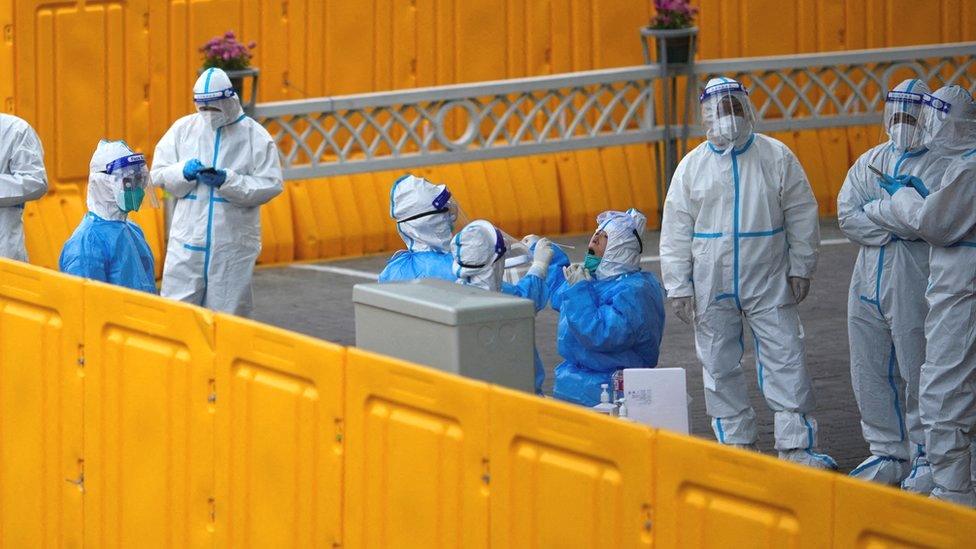 Policemen and staff workers get tested for the coronavirus disease (COVID-19) at a makeshift nucleic acid testing centre inside barriers of an area under lockdown amid the coronavirus disease (COVID-19) pandemic, in Shanghai, China March 24, 2022