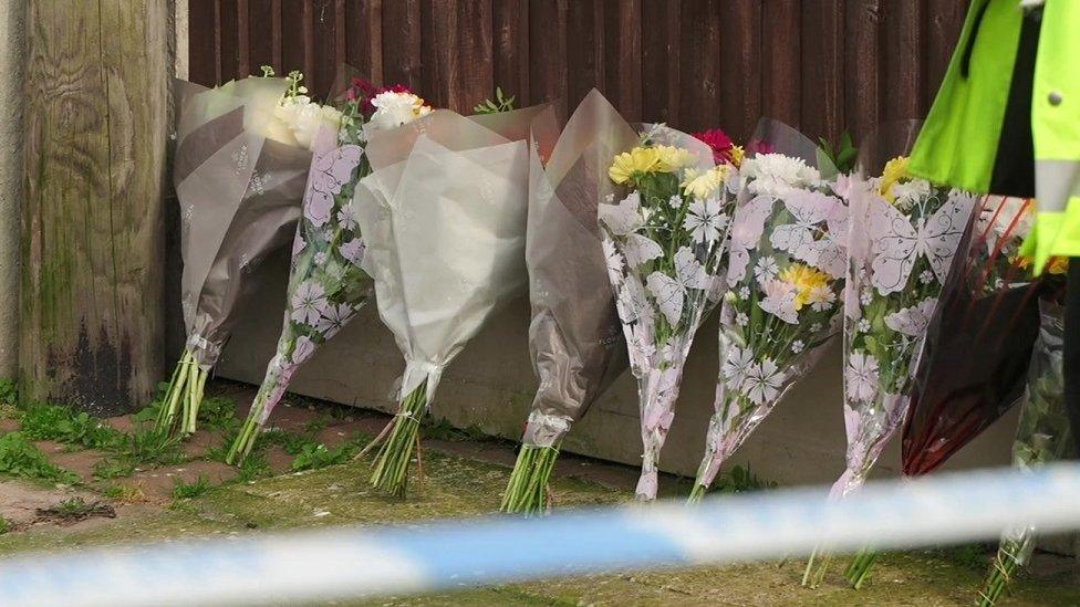 flowers laid against a wooden fence