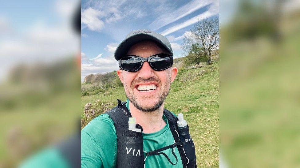 Dan Beaumont in running gear up a fell