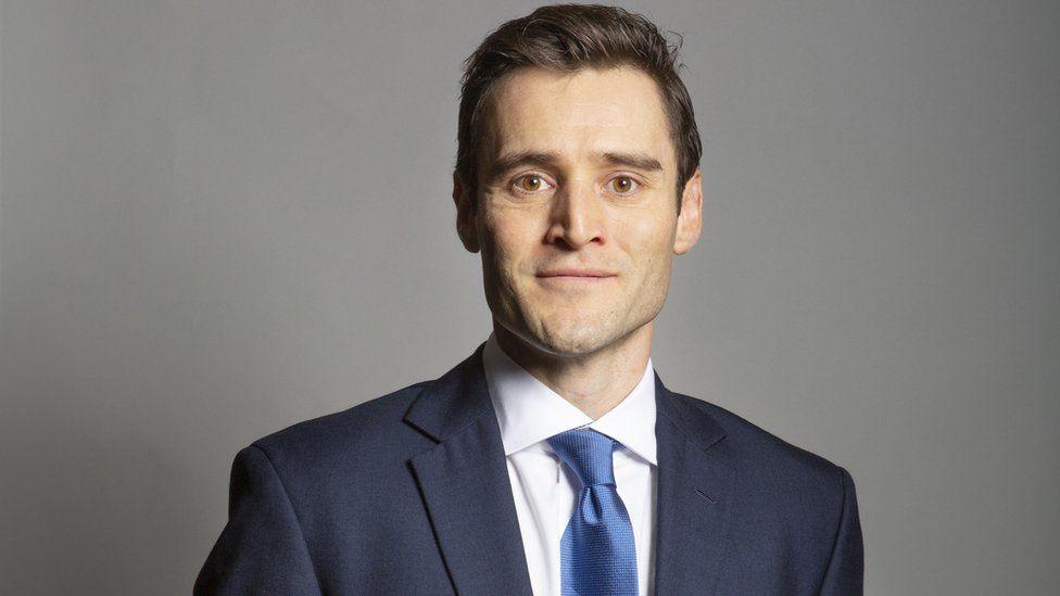 A man in a blue suit and ties