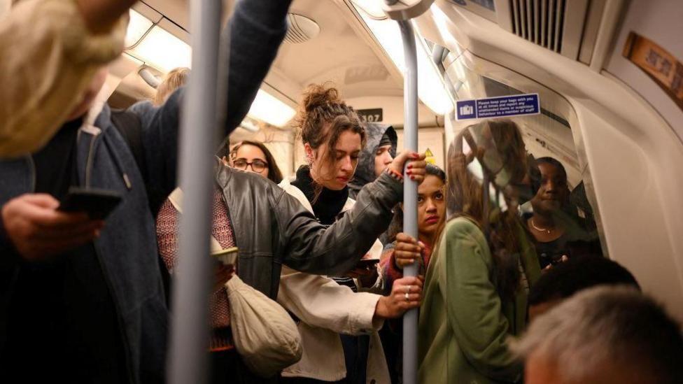 passengers on board a crowded tube train.
