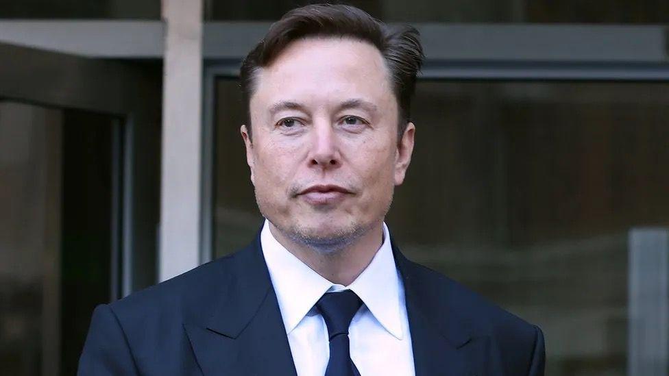 Elon Musk wearing a suit and tie