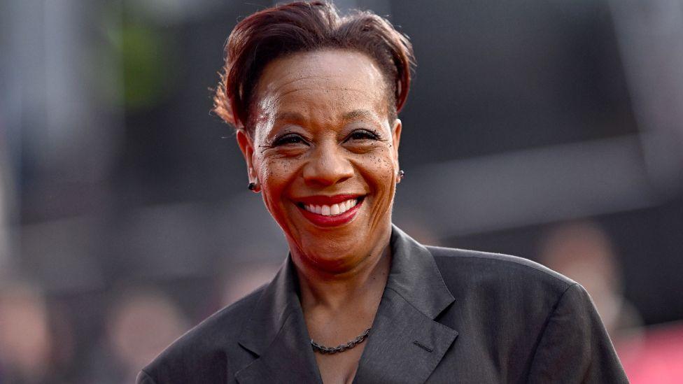 Marianne Jean-Baptiste attends the Hard Truths Headline Gala during the 68th BFI London Film Festival at The Royal Festival Hall on October 14, 2024 in London, England. She has short black hair and is smiling. She is waring a grey jacket.