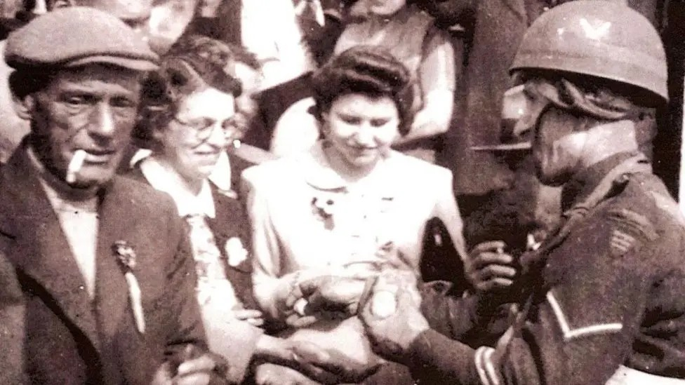 A man with a cap and smoking a cigarette and two women in the 1940s and a serviceman in a sepia picture.