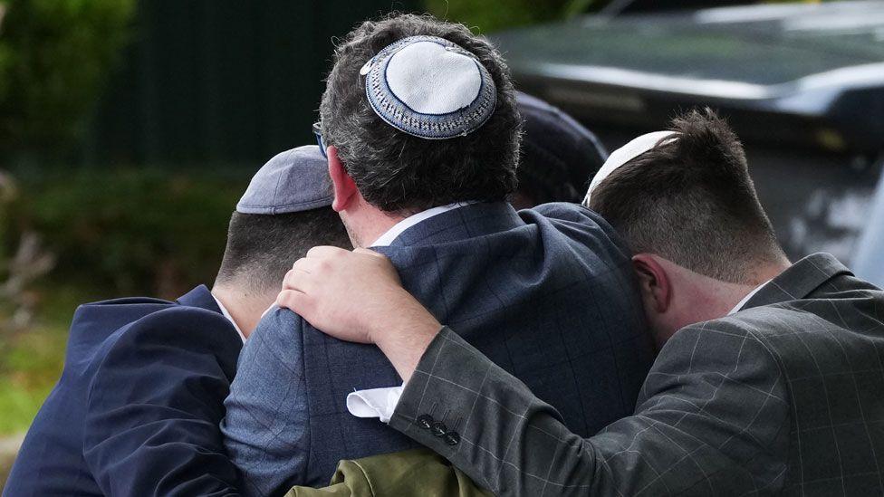 Members of the public react as they gather near the Heaton Park Hebrew Congregation Synagogue, where multiple were injured after stabbing and car attack on Yom Kippur, on October 2, 2025 