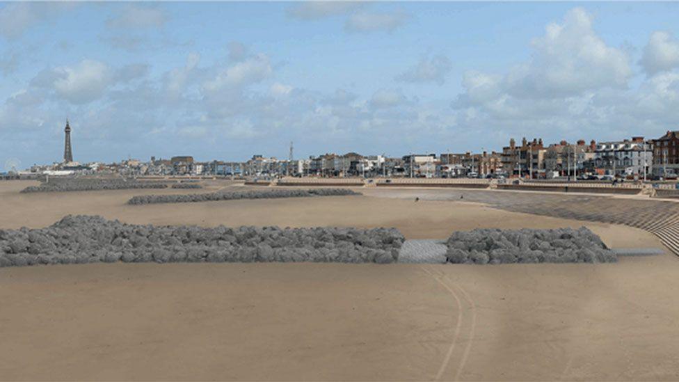 Visualisation of rock headlands along the beach. They are long stretches of grey rocks edging from the steps to the beach towards the sea. Blackpool's coastline can be seen in the distance in the background with the tower to the left