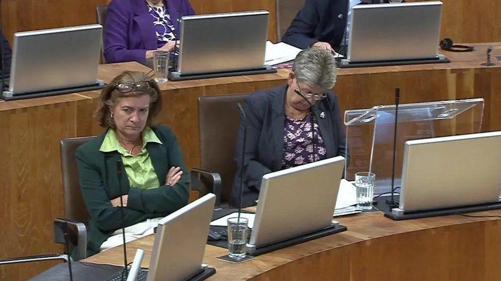 Eluned Morgan a Jane Hutt yn siambr y Senedd ddydd Mawrth