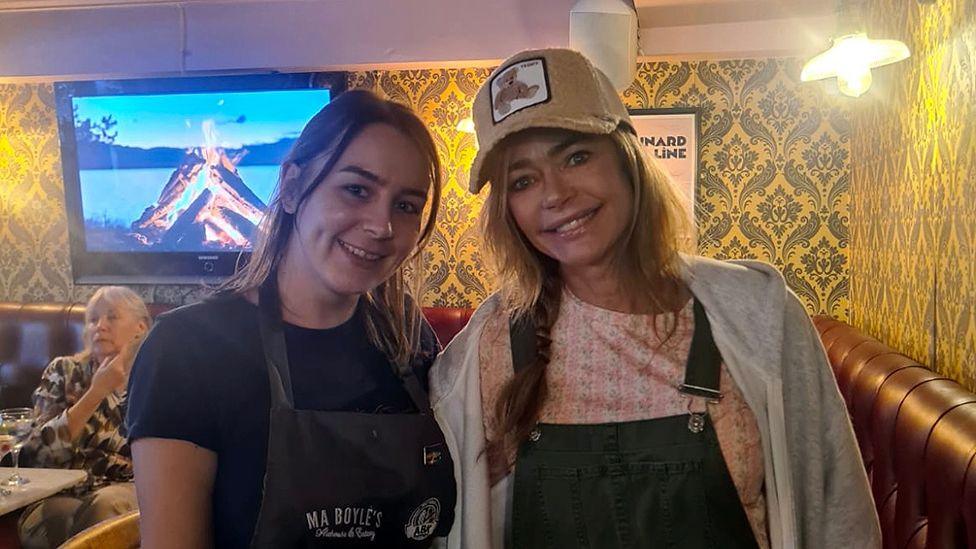 Both deputy manager of Ma Boyle's Amy Kelly and Hollywood star Denise Richards smiling during her visit to the restaurant.