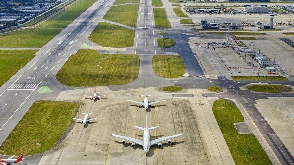 aerial shot of planes lined up at the Gatwick Airport runway