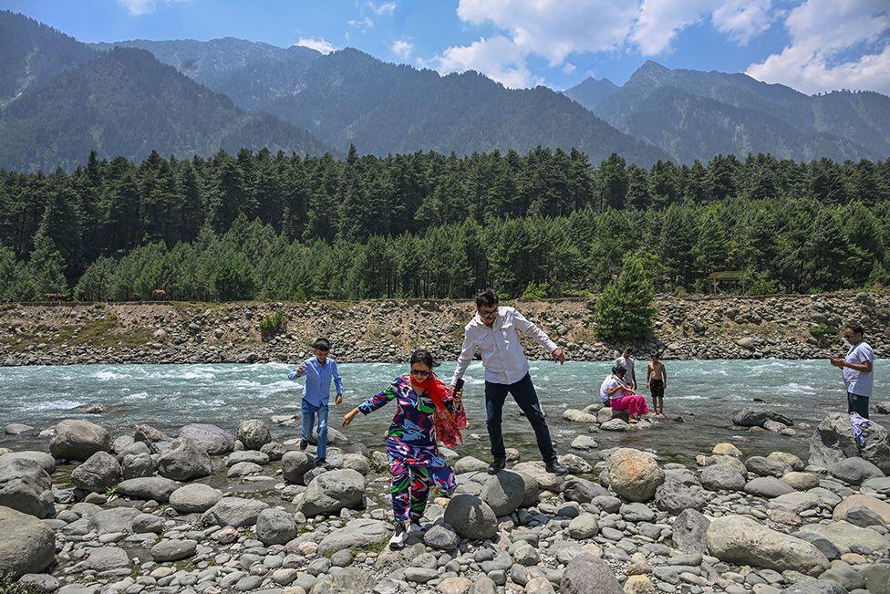 The Jaffar family enjoy the river in Pahalgam 