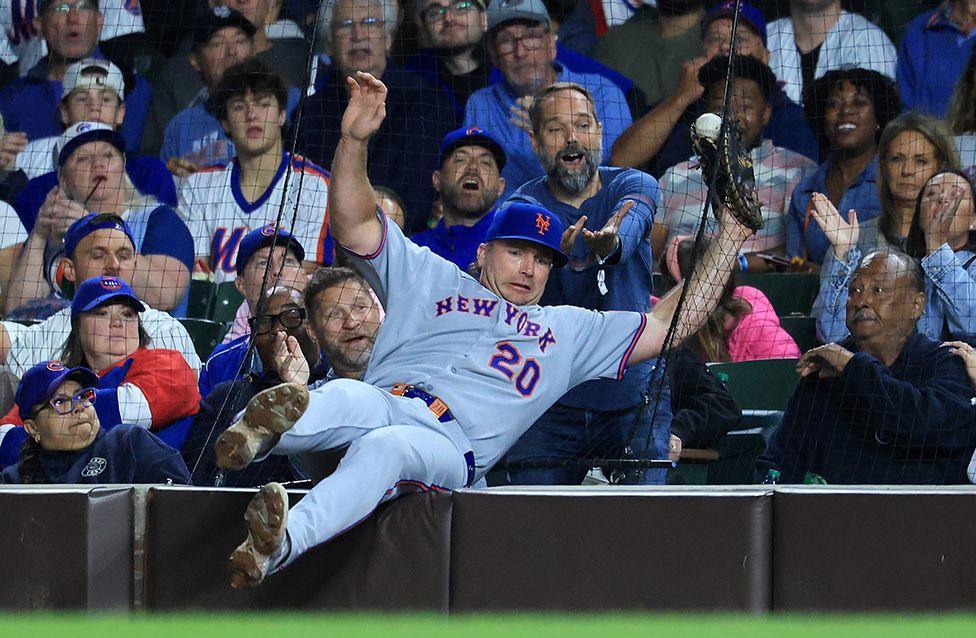 Pete Alonso of the New York Mets attempts to catch a fly ball while falling into the stands during the fifth inning against the Chicago Cubs at Wrigley Field in Chicago. Photo by Justin Casterline