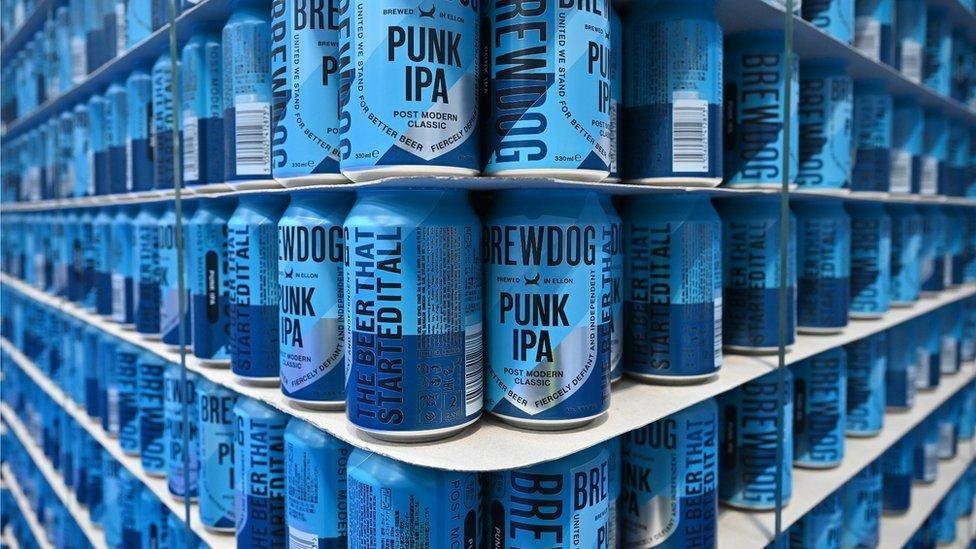 Bright blue cans of Brewdog's Punk IPA stacked to the ceiling
