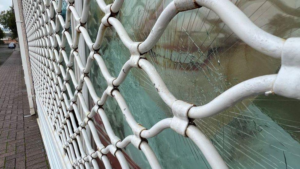 The smashed window of the office of Lee Waters and Dame Nia Griffith