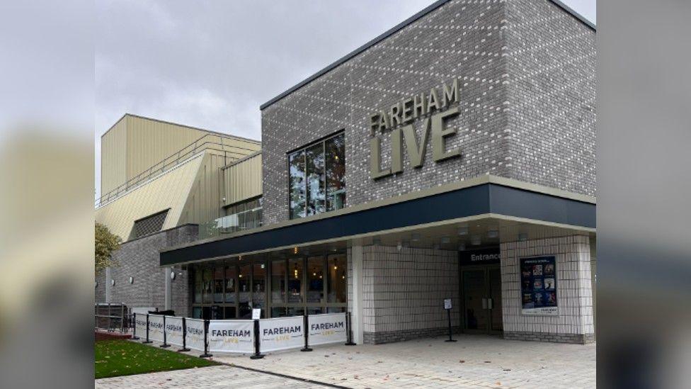 Outside the theatre of Fareham Live - grey, white and blue building with the words Fareham Live written in gold.